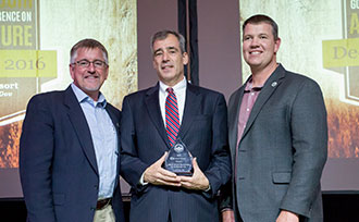 Photo of three men in awards ceremony