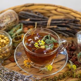 Herbal tea brewed in cup with dry herbs
