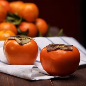 Orange persimmons on kitchen towel