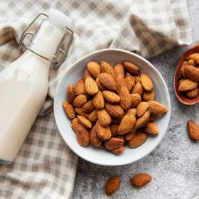 almonds in a bowl with almond milk at it's side