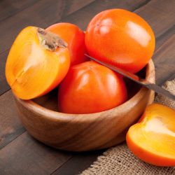 Bowl of persimmons, with one cut open