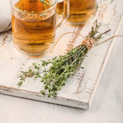 Bundle of Thyme next to a warm drink