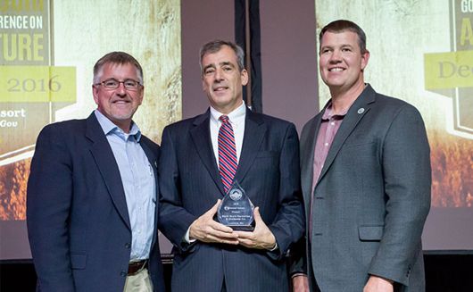 Photo of three men in awards ceremony